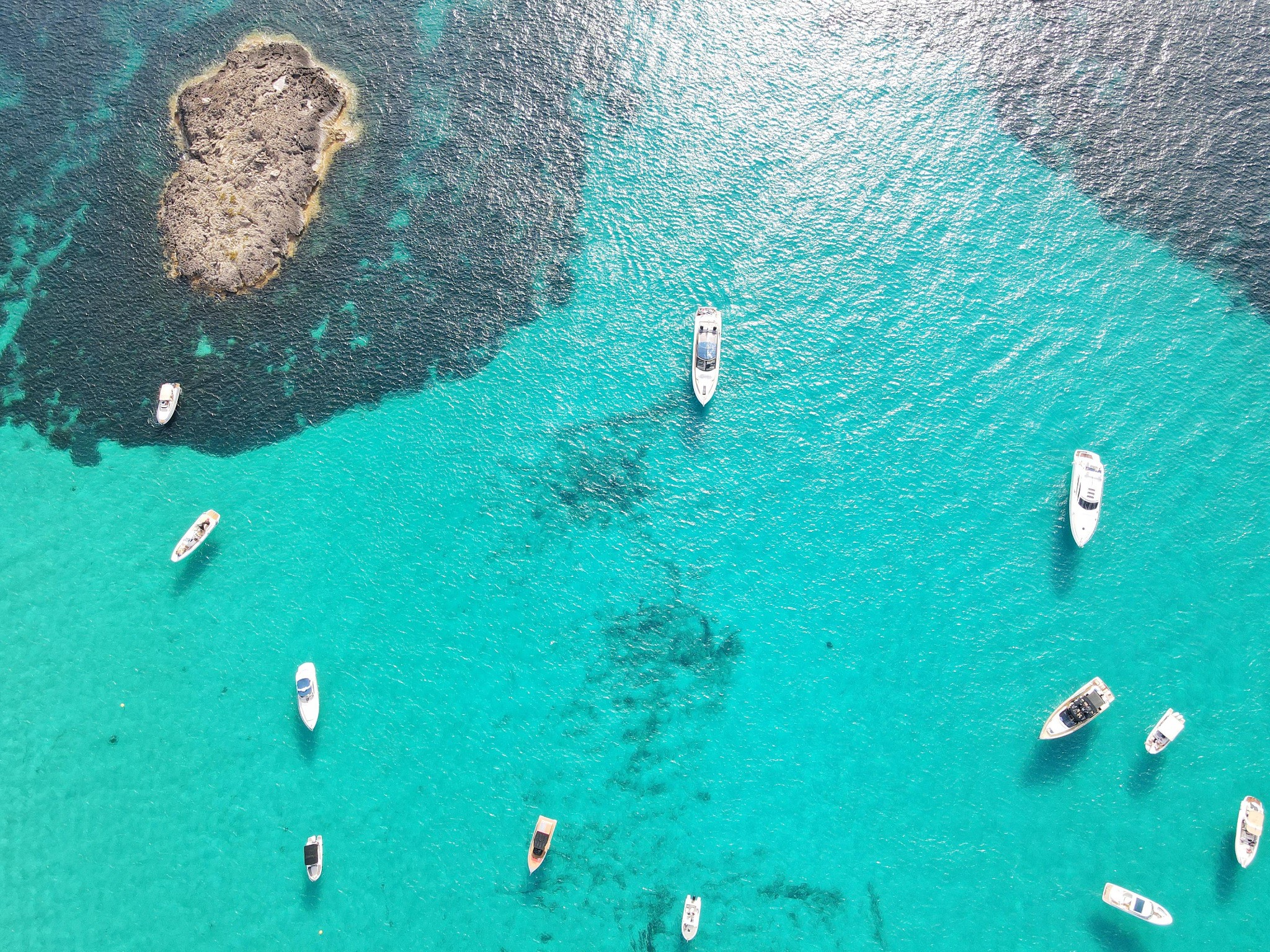 Aerial view of boats anchored in crystal-clear waters