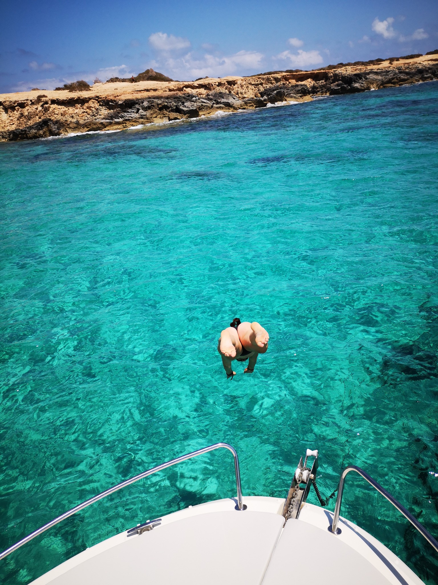 Person jumping from the bow of the boat into the water