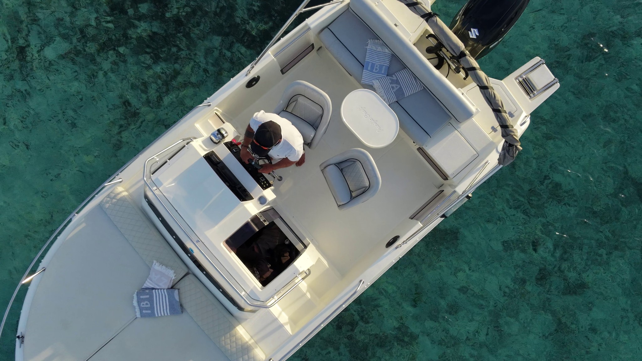 Top aerial view of the boat in crystal-clear waters