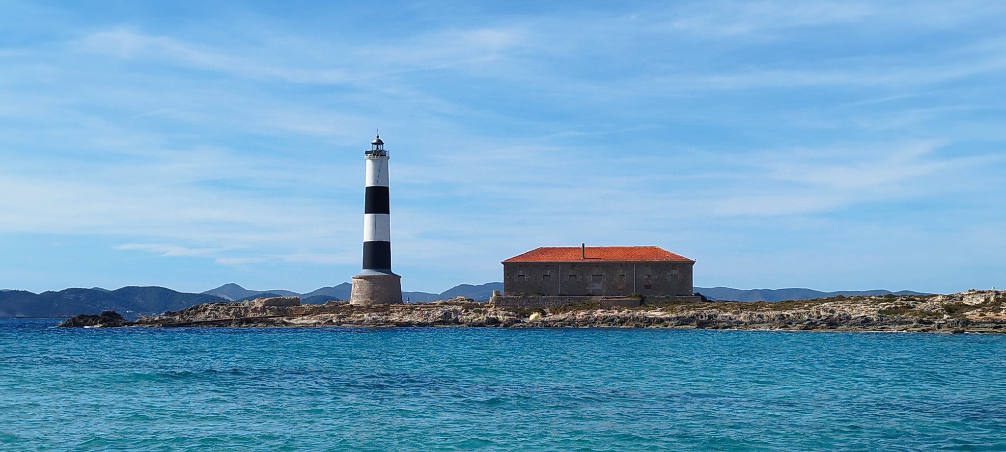 Black and white lighthouse seen from the sea