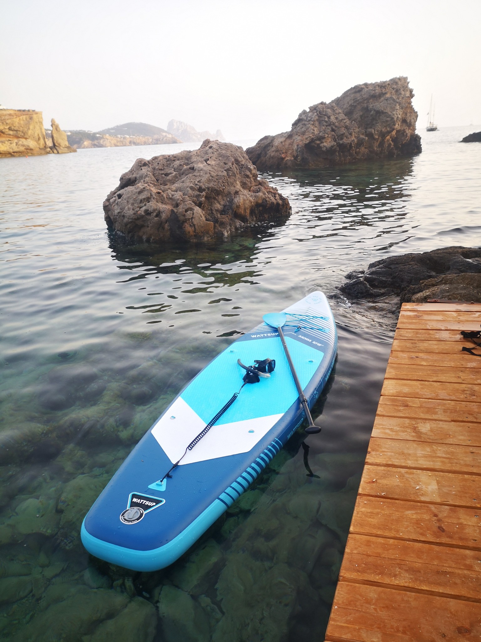 Paddle board next to a pontoon in a cove