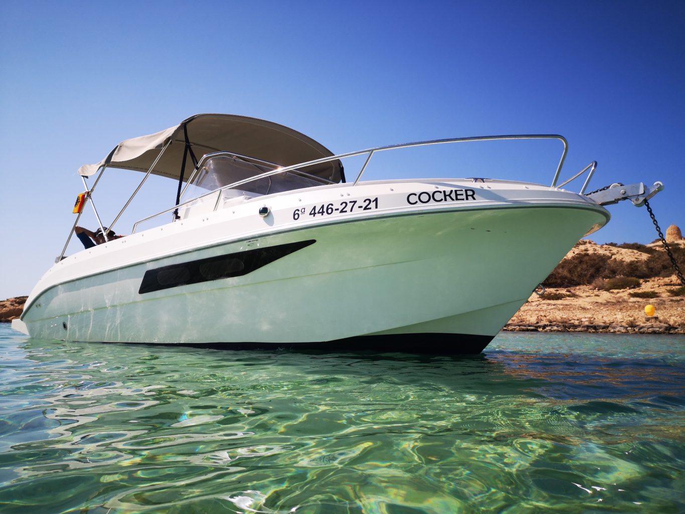 Barco alquiler Formentera detalle Detalle lateral de barco fondeado en aguas claras de Formentera