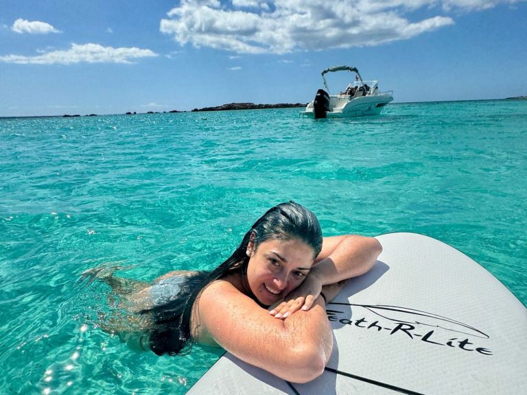 Foto paddle surf con el barco de fondo Cliente disfrutando de paddle surf en calas de Formentera