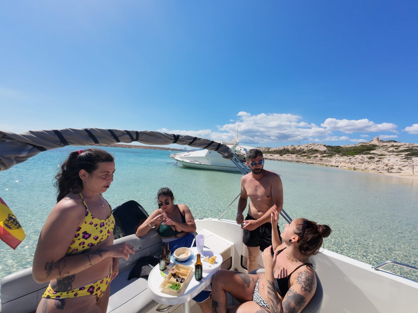 Grupo reducido disfrutando en barco Ibiza Formentera Picoteo en barco, risas con amigos Formentera Ibiza